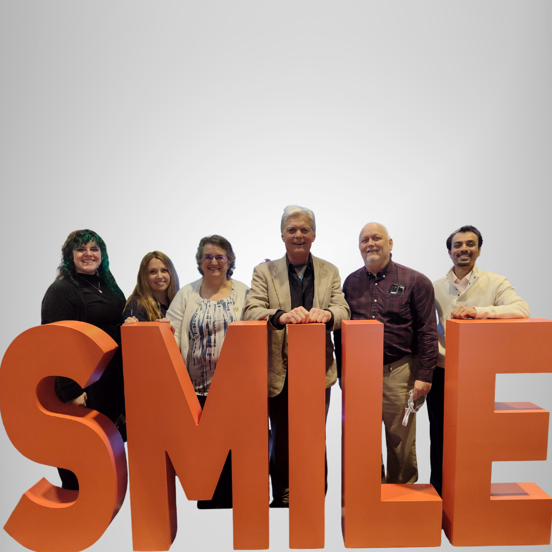 JA Haselhorst Naperville dentist team standing behind a sign that says Smile.