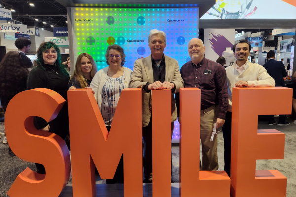 JA Haselhorst Naperville dentist team standing behind a sign that says Smile.