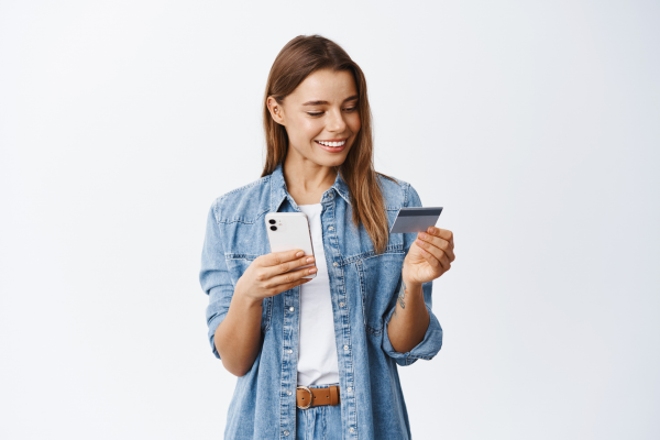 A woman paying a bill on her phone using a credit card.